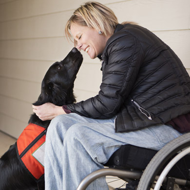 Woman with a disability smiling and touching noses with her service dog